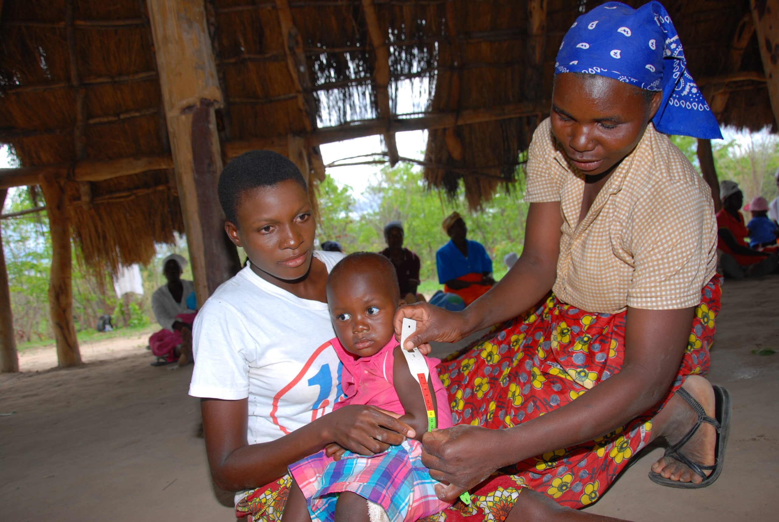 Village health worker showing how to measure Mid Upper Aarm Circumfarance MUAC scaled