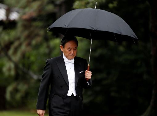 FILE PHOTO: Japan's Chief Cabinet Secretary Yoshihide Suga arrives at the ceremony site where Emperor Naruhito will report the conduct of the enthronement ceremony at the Imperial Sanctuary inside the Imperial Palace in Tokyo, Japan October 22, 2019. REUTERS/Kim Hong-ji
