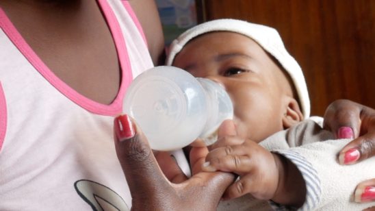 African stock video of a rural black mother feeding her gorgeous child from a Bottle 2 548x308 1
