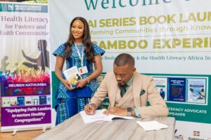 Zimbabwean pharmacist Reuben Katumba signs a copy of his health literacy book for a delegate during the launch of his seven-book series in Zimbabwe.