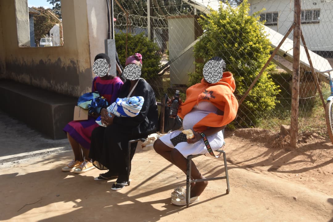 Teenage mothers, including Rhoda (name changed), wait with other young women at Wadzanayi Clinic in Shamva District, where many adolescents access maternal and reproductive health services.
