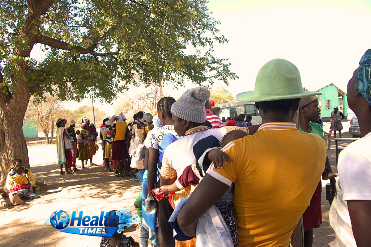 Women holding their babies queue at a Zimbabwean health facility as new AIDS 2026 data warn that PEPFAR disruptions have reduced HIV treatment support for thousands of children.