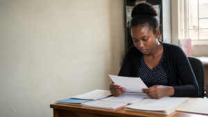 Young Zimbabwean woman reviewing legal and healthcare information about pregnancy after rape.