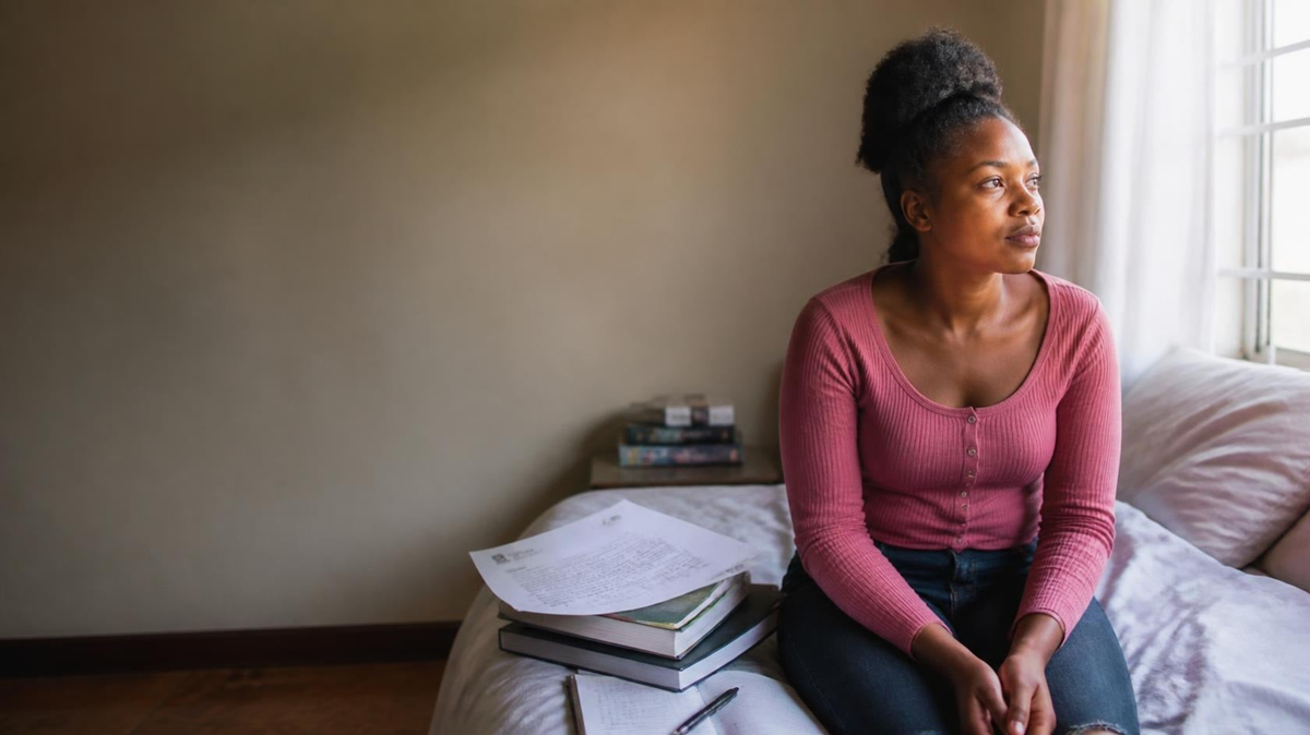 A young Zimbabwean woman sits thoughtfully on her bed as she faces an uncertain future following a pregnancy resulting from rape.