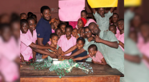 CURE founder cutting a cake with school children with disabilities during a community support programme in Zimbabwe